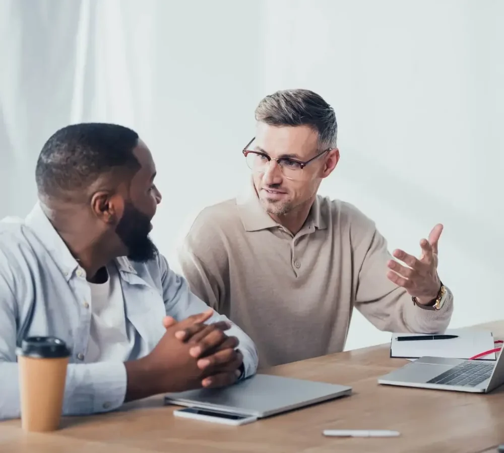Two WordPress developers discussing a web project during a team meeting at GreenyWebs agency.
